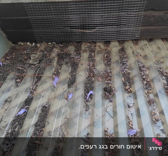 רעפים חומים עם רשת מתכת על הגג